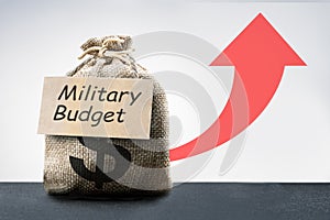 cost of war concept with money bag, dollar sign, military budget text and up arrow.