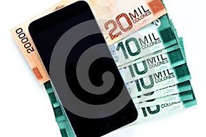 Costa Rica currency, banknotes lying together with a mobile phone, white background