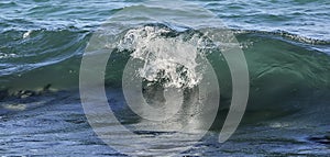 Costal sea/ocean crashing wave with foam on its top photo