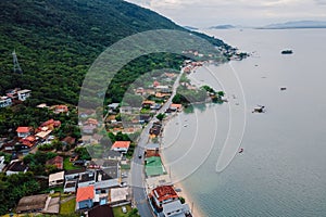 Costal village in Florianopolis, Brazil. Coastline with mountains and buildings photo