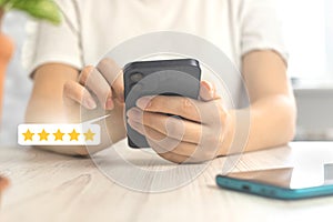 Costumer reviews concept with rating or feedback icon, gold five star review the service, woman with smartphone