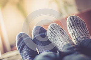 Cosy relaxing in the wintertime at home: Couple with woollen socks is lying on the couch