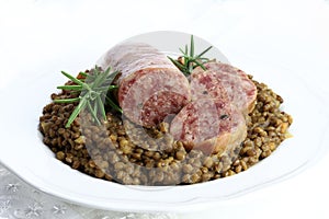 Cotechino with lentils served on a plate and a glass of red wine. Christmas holiday.