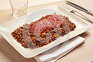 Cotechino and lentils served on a platter