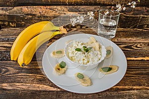 Cottage cheese with banana for breakfast. Wooden background