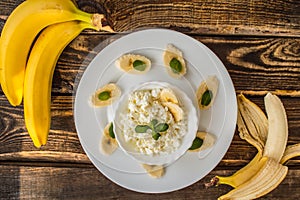 Cottage cheese with banana for breakfast. Wooden background