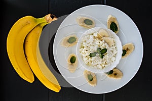 Cottage cheese with banana for breakfast. Wooden background