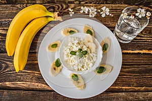 Cottage cheese with banana for breakfast. Wooden background