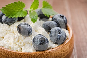 cottage cheese with blueberry and mint in a wooden bowl/cottage