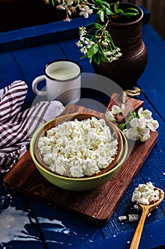 Cottage cheese in a bowl on blue wooden table