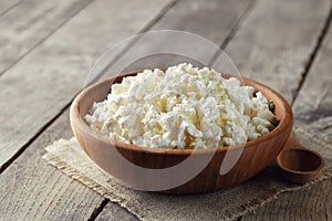 cottage cheese in brown wooden bowl with spoon