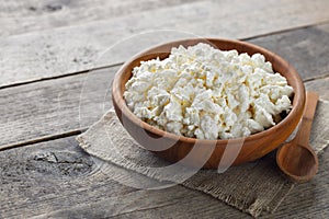 cottage cheese in brown wooden bowl with spoon