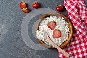 Cottage cheese with fresh strawberry in a wooden bowl, healthy breakfast concept, top view