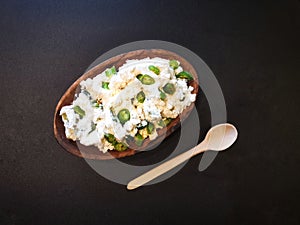 Cottage cheese with green pepper on the black surface