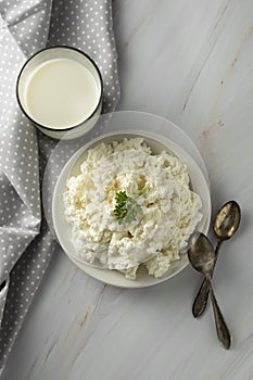 Cottage cheese isoalted on light, marble background. Dairy products, calcium and protein. Healthy breakfast. Vertical image
