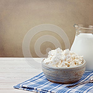 Cottage cheese and jug with milk on white wooden table. Jewish holiday Shavuot concept