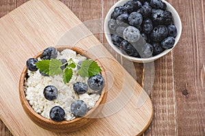 cottage cheese with mint and berries in a wooden bowl and blueberry/cottage cheese with mint and berries in a wooden bowl and blu