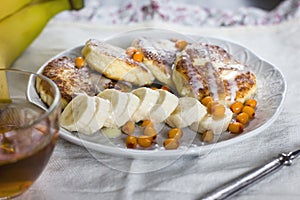 Cottage cheese pancakes with banana slices and sea buckthorn berries. Healthy breakfast. View from top