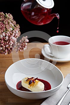 Cottage cheese pancakes with berry sauce and red tea. breakfast morning table with flowers