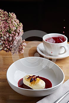 Cottage cheese pancakes with berry sauce and red tea. breakfast morning table with flowers