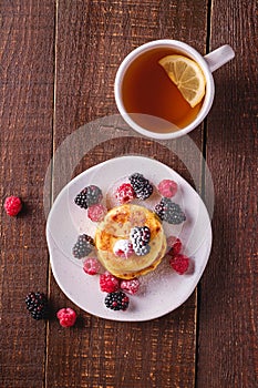 Cottage cheese pancakes, curd fritters dessert with raspberry and blackberry berries in plate near