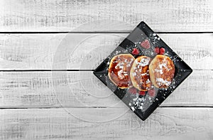 Cottage cheese pancakes on dark plate over white rustic wooden t