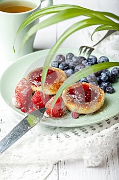 Cottage cheese pancakes with raspberry jam, blueberries and strawberries