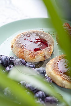 Cottage cheese pancakes with raspberry jam, blueberries and strawberries