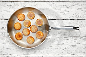 Cottage cheese pancakes. Syrniki in a frying pan. Cheesecakes, top view.