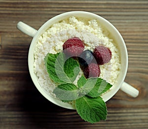 Cottage cheese with raspberries and blueberries in a bowl for healthy breakfast