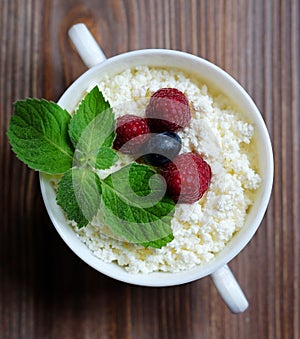 Cottage cheese with raspberries and blueberries in a bowl for healthy breakfast with ripe berries