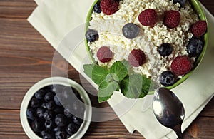 Cottage cheese with raspberries and blueberries in a bowl for healthy breakfast with ripe berries