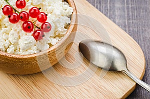 Cottage cheese with red berries and mint in a wooden bowl/cottage cheese with red berries and mint in a wooden bowl. Top view
