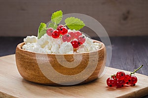 Cottage cheese with red currant and mint in a wooden plate/cottage cheese with red currant and mint in a wooden plate. selective