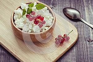 Cottage cheese with red currant in a wooden plate/cottage cheese