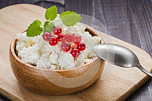 Cottage cheese with red currant in a wooden plate/cottage cheese with red currant in a wooden plate. selective focus