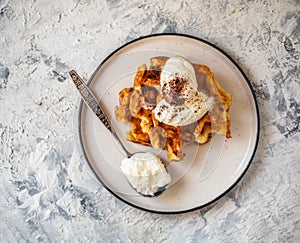 Cottage cheese waffles with ice cream and grated chocolate on a light plate