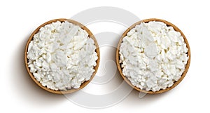 Cottage cheese in wooden bowl isolated on white background, top view