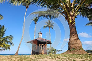 Cottage on the coconut beach. The clock tower or lifeguard tower , Hut against the blue sky