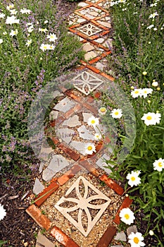 Cottage Garden Path with Bricks and Stone Pavers Surrounded by Daisies and Catmint Flowers