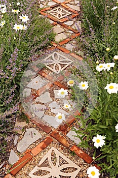 Cottage Garden Path with Bricks and Stone Pavers Surrounded by Daisies and Catmint Flowers