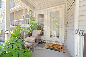 Cottage pane front door wicker armchairs and stairs viewed at the home entrance