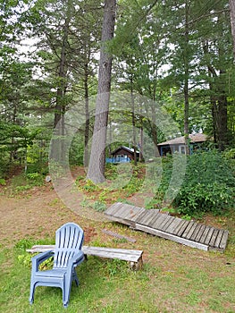 Cottage in the trees with dock and chair