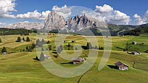 Cottages in the Dolomites mountains at Seiser Alm plateau, summer day, Italy