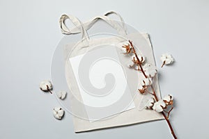 Cotton bag and empty sheet on light gray background, space for text photo