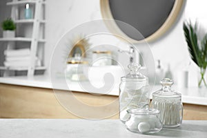 Cotton balls, swabs and pads on grey table in bathroom