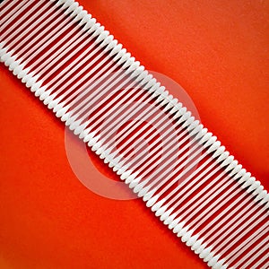 Cotton buds arranged diagonals in a row on a red background.