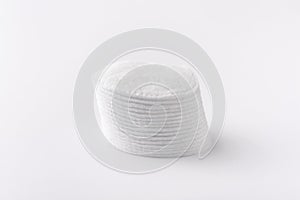 Cotton disks are stacked on a white background