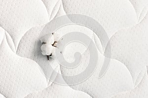 Cotton flowers on a comfortable mattress texture background top view. White texture of mattress bedding background. Healthy sleep