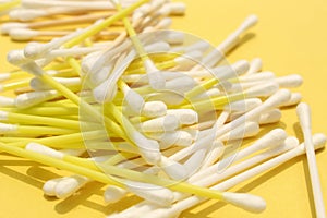 Cotton made ear buds all together close display on yellow background.